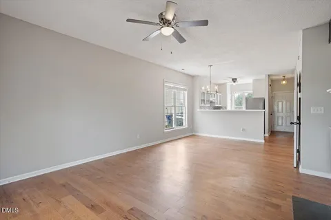 a view of a kitchen with wooden floor and a ceiling fan
