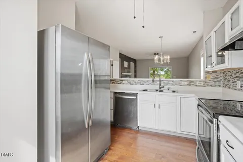 a kitchen with a refrigerator sink and cabinets