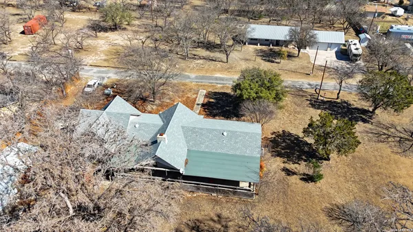 an aerial view of a house with yard and lake view
