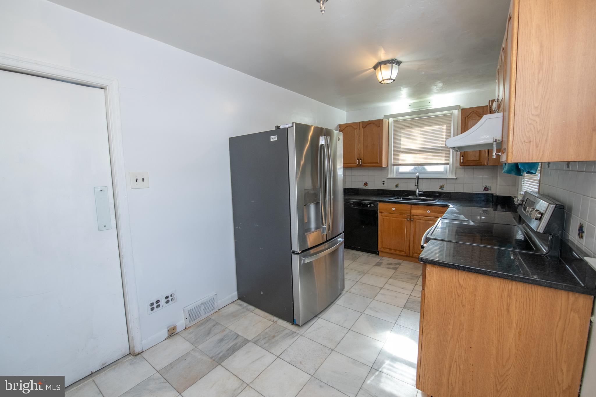 7820 Haines Road Cheltenham, PA 19012 - Photo 11 of 51 a kitchen with stainless steel appliances granite countertop a refrigerator a stove a sink and a microwave