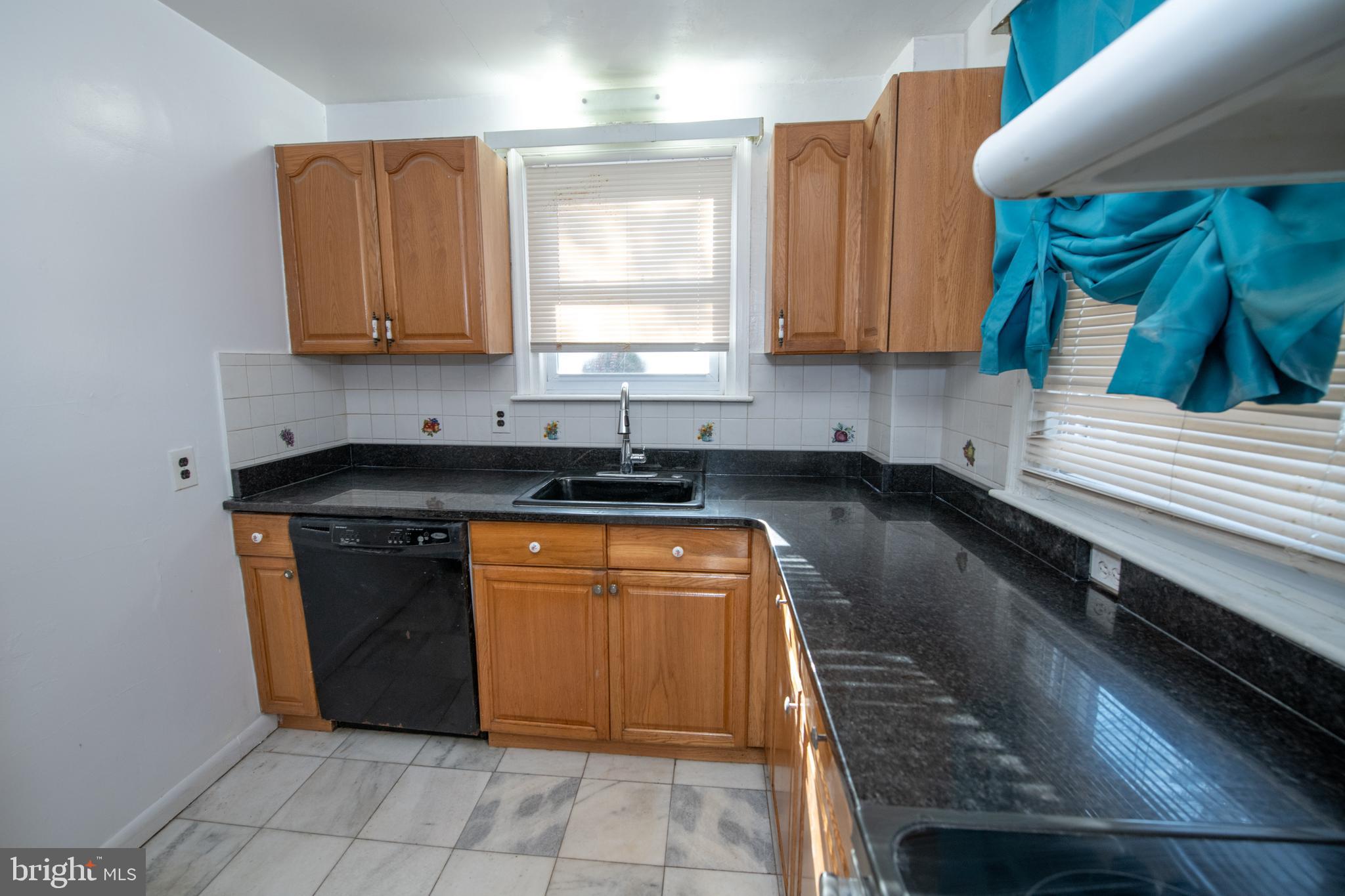 7820 Haines Road Cheltenham, PA 19012 - Photo 12 of 51 a kitchen with granite countertop a sink a stove and cabinets