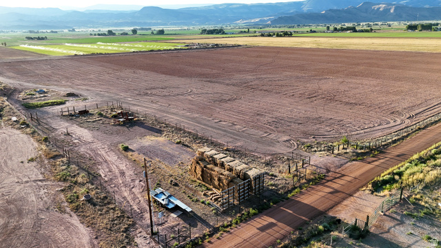 1000 East Mink Farm Road Richfield, UT 84701 - Photo 11 of 29 Expansive open land with a tilled field, partially fenced perimeter, and a dirt access road