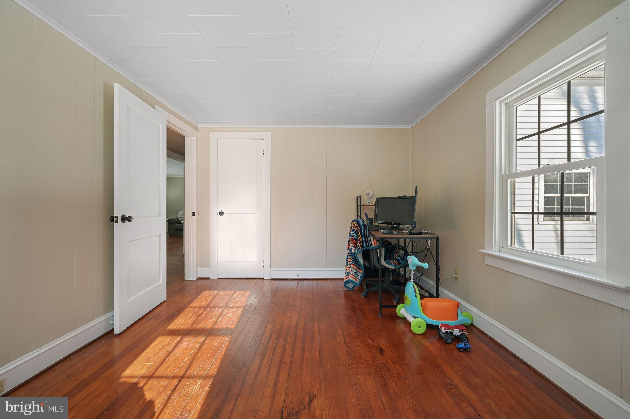 12739 Greensboro Road Greensboro, MD 21639 - Photo 24 of 28 an empty room with wooden floor and a window