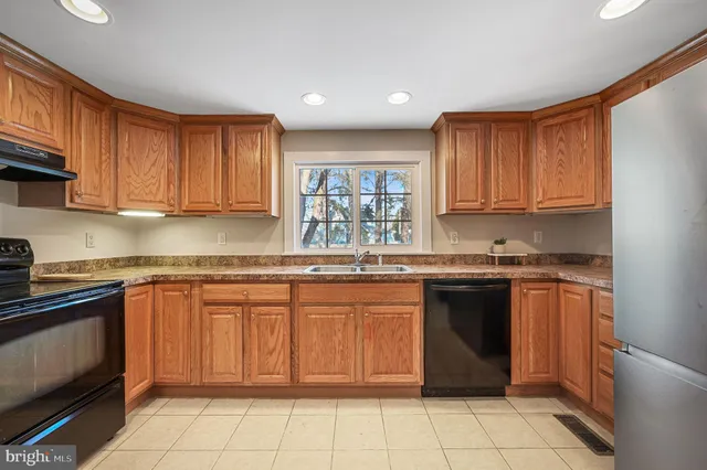 a open kitchen with stainless steel appliances granite countertop a refrigerator and a stove