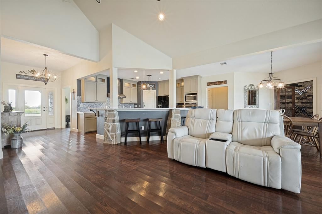 8400 Holder Road Northlake, TX 76247 - Photo 7 of 36 Vaulted ceilings, wood-finish flooring, kitchen with stone-accented breakfast bar, pendant lighting, and recessed lighting