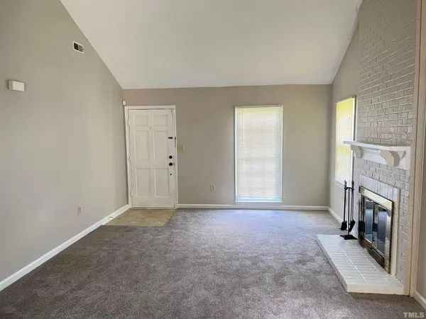 a view of an empty room with a fireplace and a window
