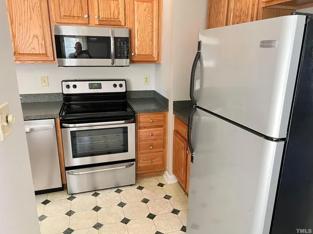 a kitchen with stainless steel appliances a refrigerator stove and microwave