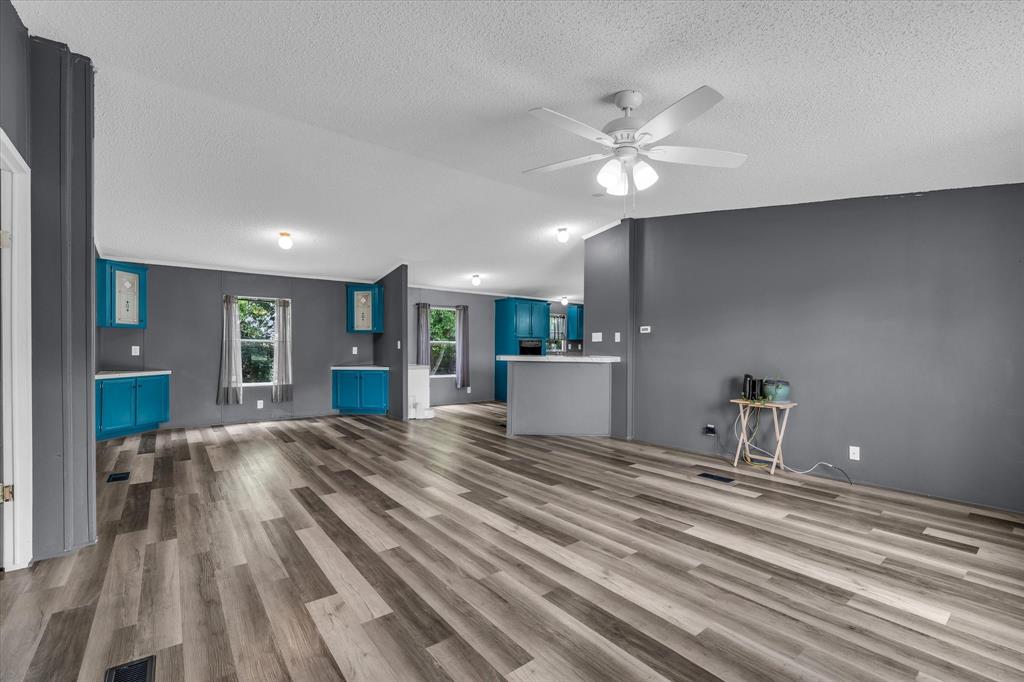 3615 Spring Valley Road Lorena, TX 76655 - Photo 3 of 33 Spacious interior featuring wood-finish flooring, a ceiling fan with integrated lighting, and a neutral wall palette