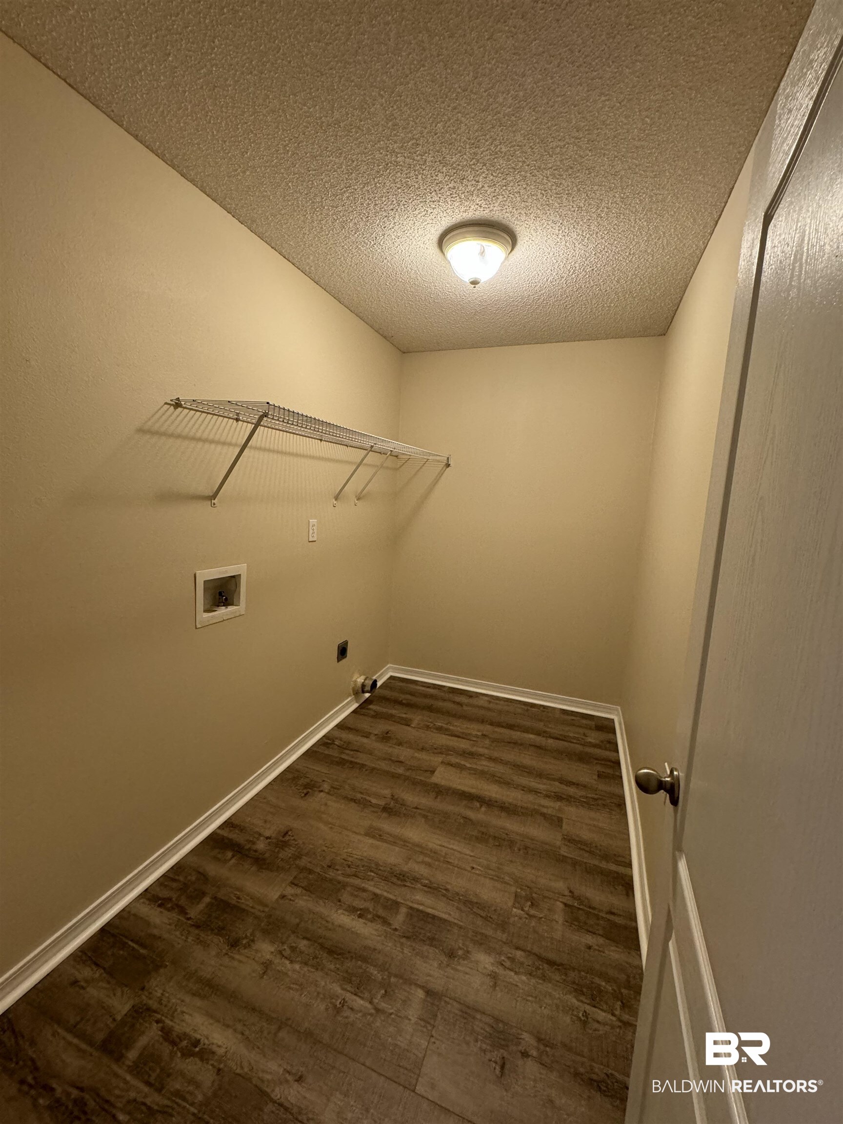 32769 Arbor Ridge Circle Lillian, AL 36549 - Photo 32 of 36 Laundry room featuring hookup for a washing machine, a textured ceiling, dark wood-type flooring, and hookup for an electric dryer