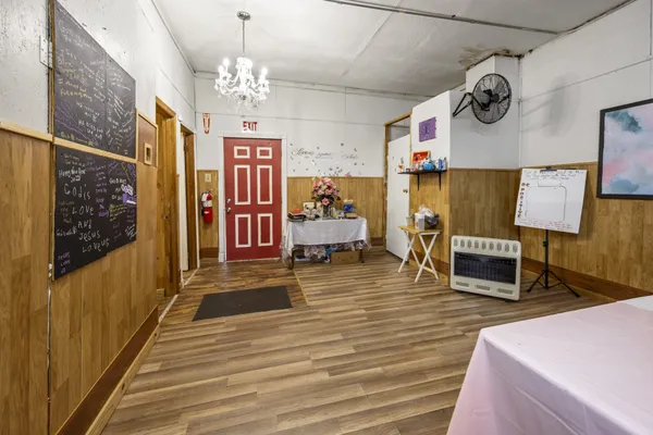 a hallway with wooden floor and chandelier