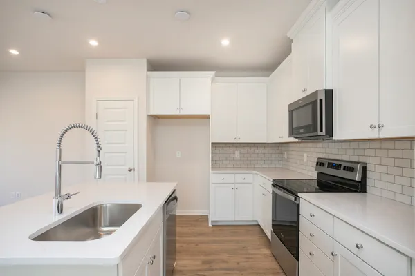 a kitchen with kitchen island a sink stainless steel appliances and cabinets