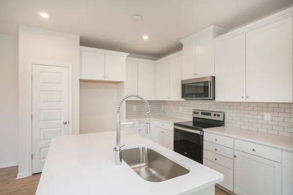 a kitchen with granite countertop a sink and white cabinets