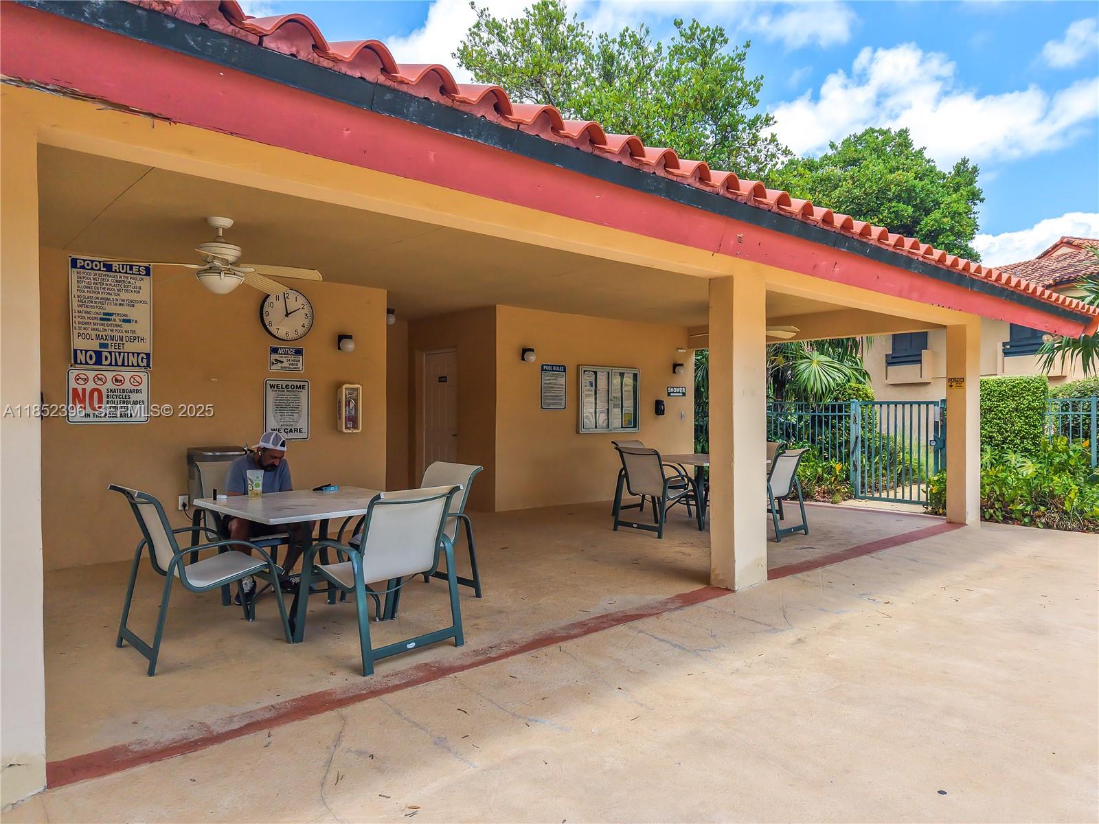 10194 Southwest 77th Court Miami, FL 33156 - Photo 20 of 25 a view of a patio with a table and chairs and floor to ceiling window