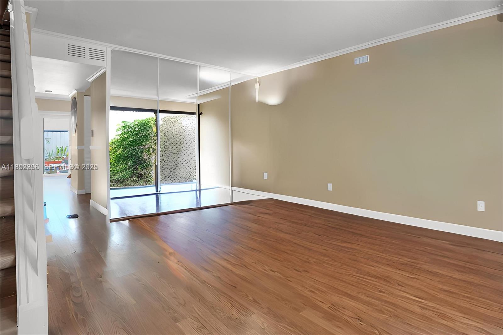 10194 Southwest 77th Court Miami, FL 33156 - Photo 3 of 25 a view of an empty room with wooden floor and a window