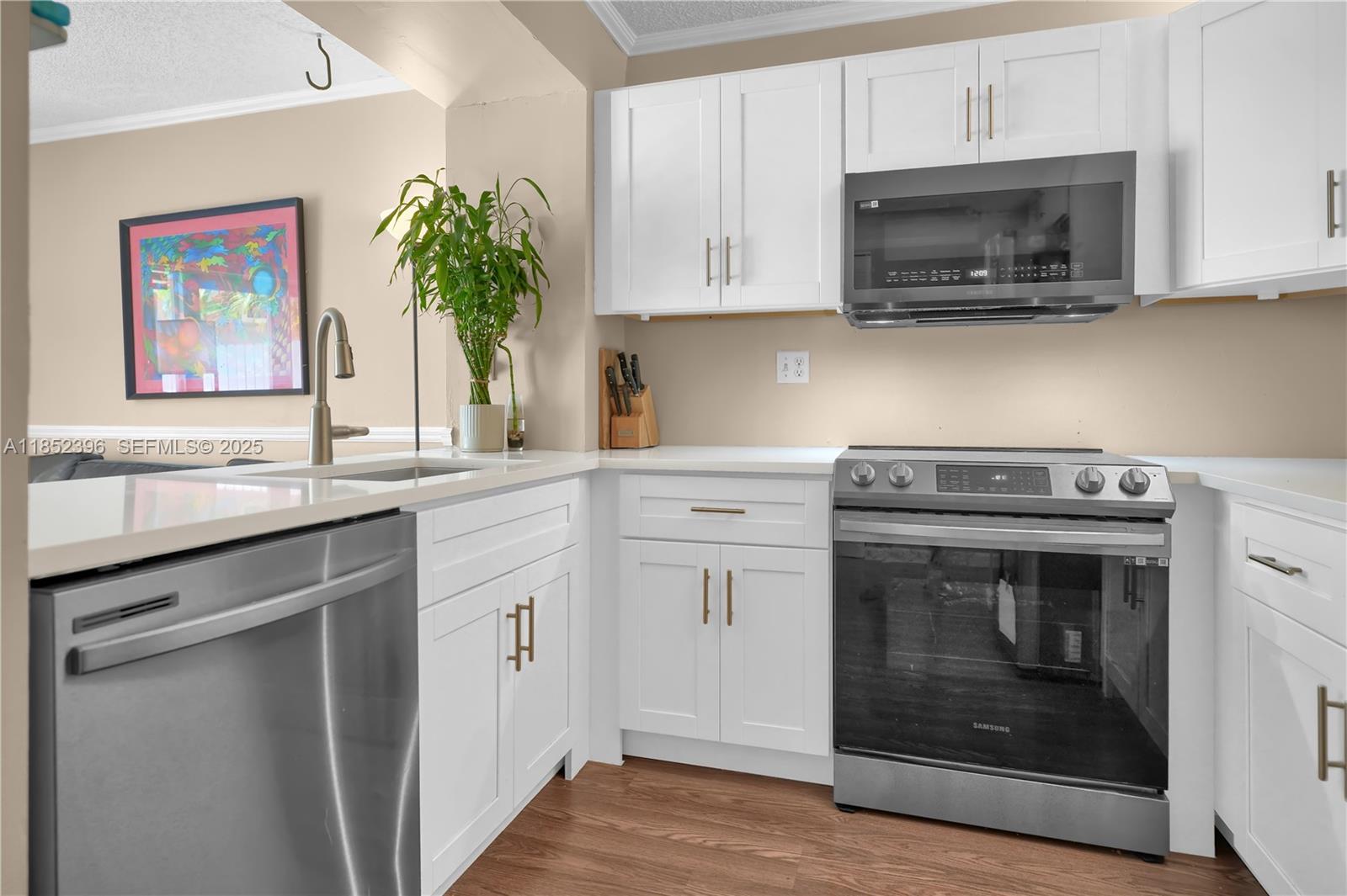 10194 Southwest 77th Court Miami, FL 33156 - Photo 5 of 25 a kitchen with stainless steel appliances granite countertop a stove a microwave and a white cabinets