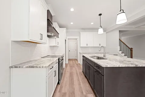 a kitchen with a stove sink and cabinets