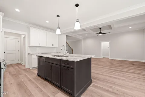 a kitchen with a sink cabinets and wooden floor