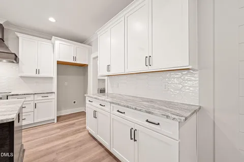 a kitchen with granite countertop white cabinets and white appliances