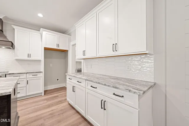 a kitchen with granite countertop white cabinets and white appliances