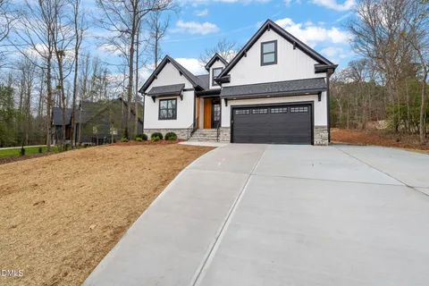 a front view of a house with yard and trees