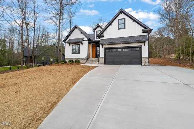 a front view of a house with yard and trees