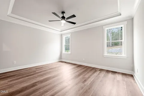 a view of a big room with wooden floor and windows