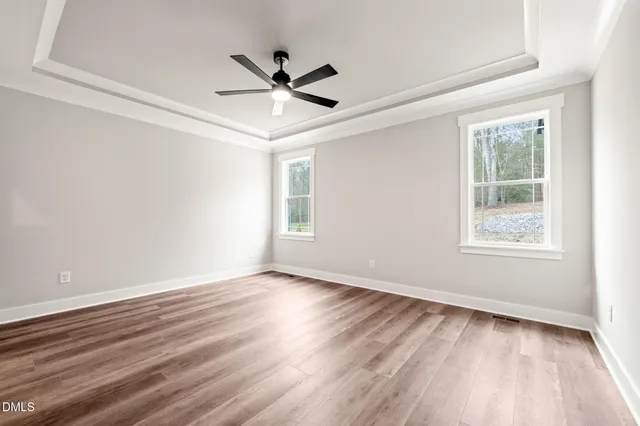 a view of a big room with wooden floor and windows