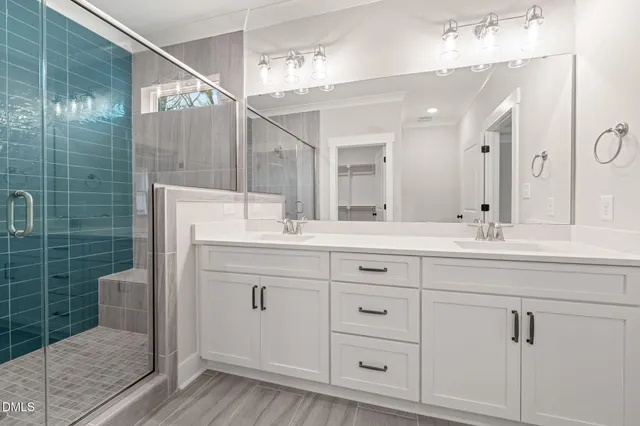 a bathroom with a double vanity sink a mirror and shower