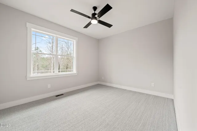 an empty room with a window and a fan