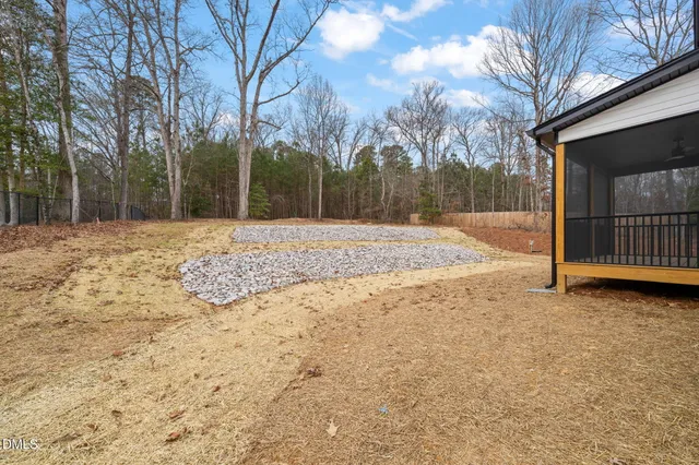 a view of a yard with wooden fence