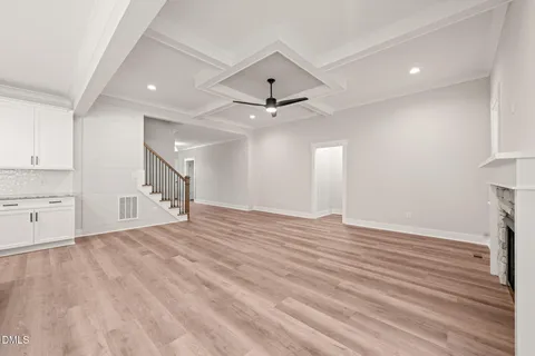 a view of an empty room with a window and a kitchen