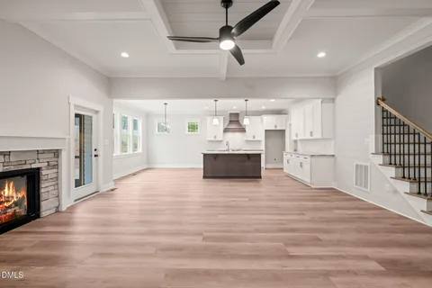 a large kitchen with cabinets wooden floor and a fireplace
