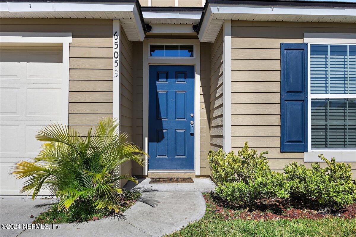 65053 Lagoon Forest Drive Yulee, FL 32097 - Photo 2 of 19 a potted plant in front of a door