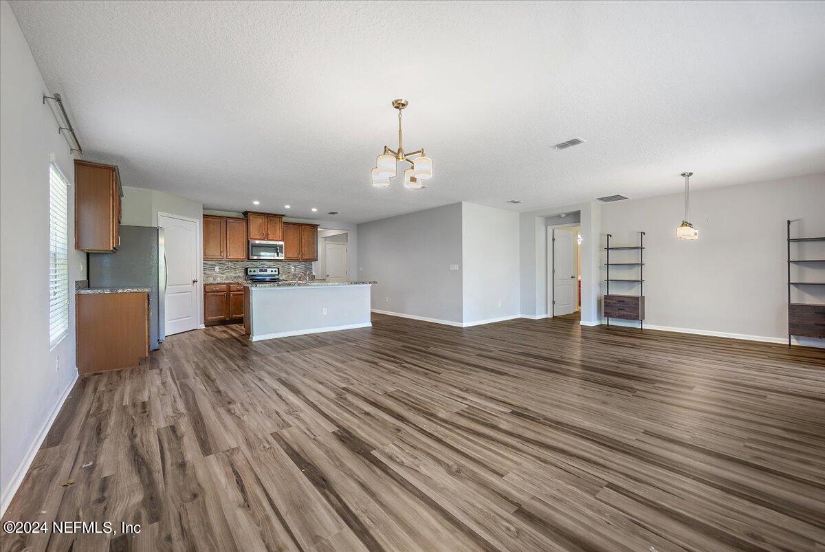 65053 Lagoon Forest Drive Yulee, FL 32097 - Photo 7 of 19 a view of a kitchen with kitchen island wooden floors stainless steel appliances