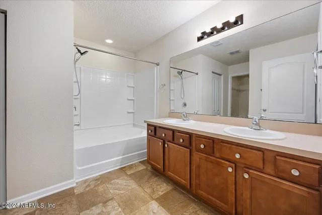 a spacious bathroom with a tub sink and mirror