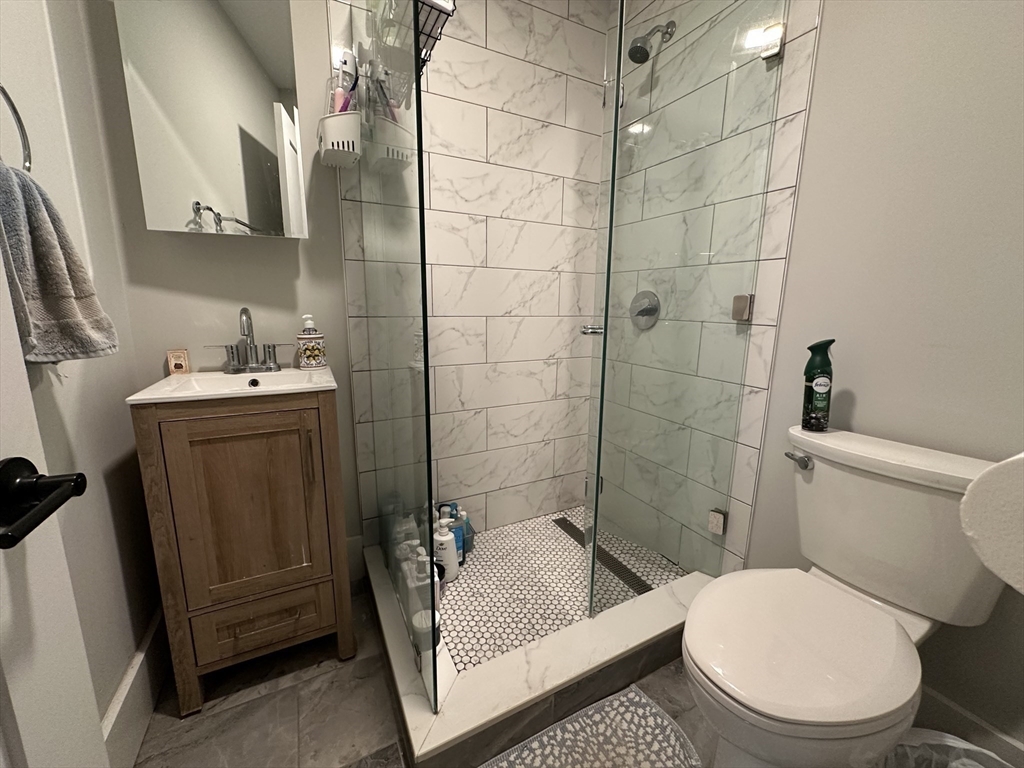 68 L Street, Unit 1 Boston, MA 02127 - Photo 5 of 12 a bathroom with a sink a toilet and shower