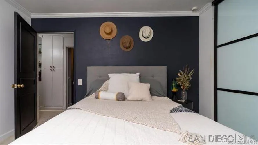 6358 Rancho Mission Road, Unit 624 San Diego, CA 92108 - Photo 10 of 16 a bedroom with a bed and a painting on the wall