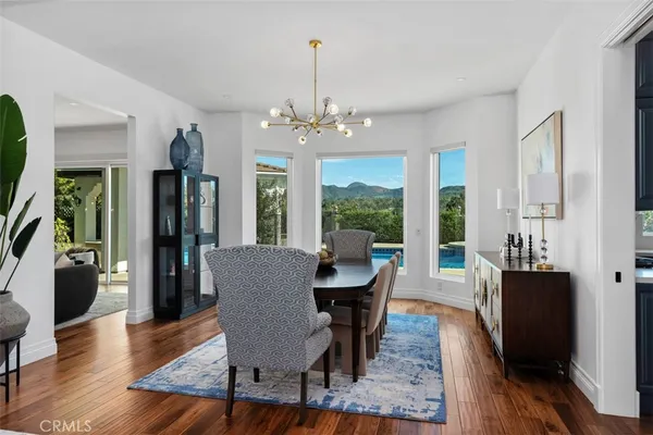 a dining room with furniture a chandelier and wooden floor