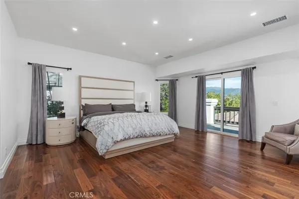 a spacious bedroom with a large bed and a wooden floor