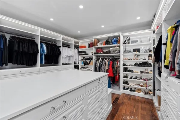 a view of walk in closet with clothes and shoes