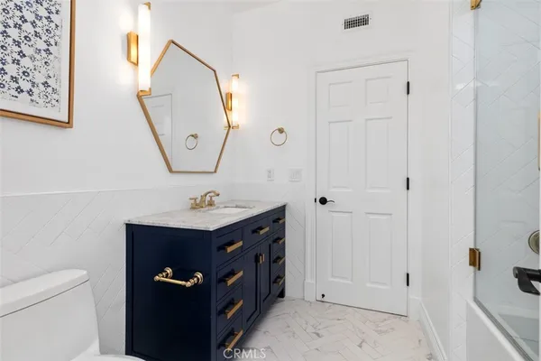 a bathroom with a sink a toilet and a mirror