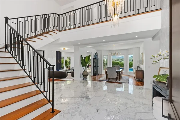 a view of staircase with living room and lots of frames on wall