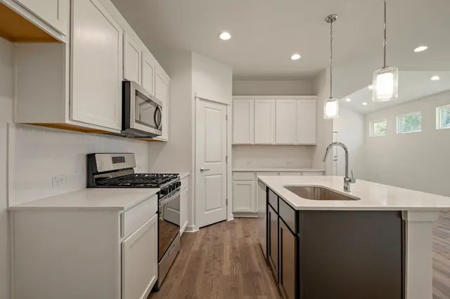 a kitchen with stainless steel appliances granite countertop a sink stove and cabinets