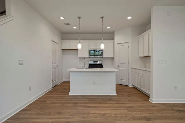 a view of kitchen with stainless steel appliances granite countertop a stove a sink and a microwave