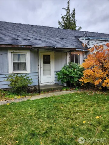 a front view of a house with a yard and plants