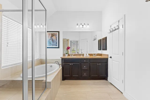 a spacious bathroom with a tub sink and mirror