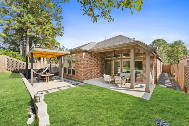 a view of a chair and table in backyard of the house