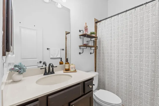 a bathroom with a sink a toilet and shower curtain