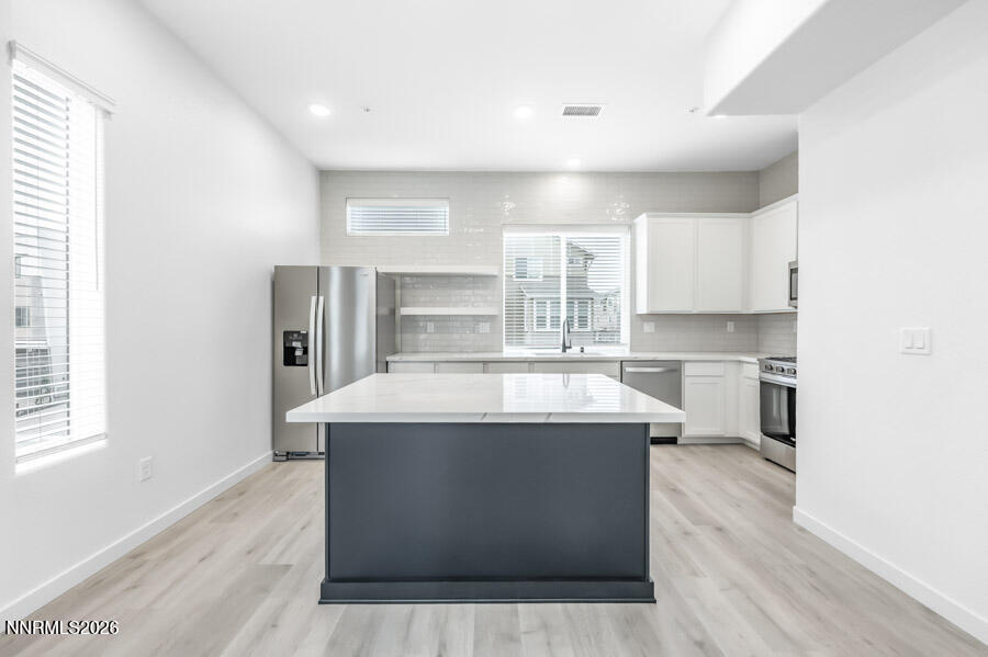 160 Rissone Lane, Unit 32 Reno, NV 89503 - Photo 1 of 5 a view with a kitchen island wooden floors and stainless steel appliances