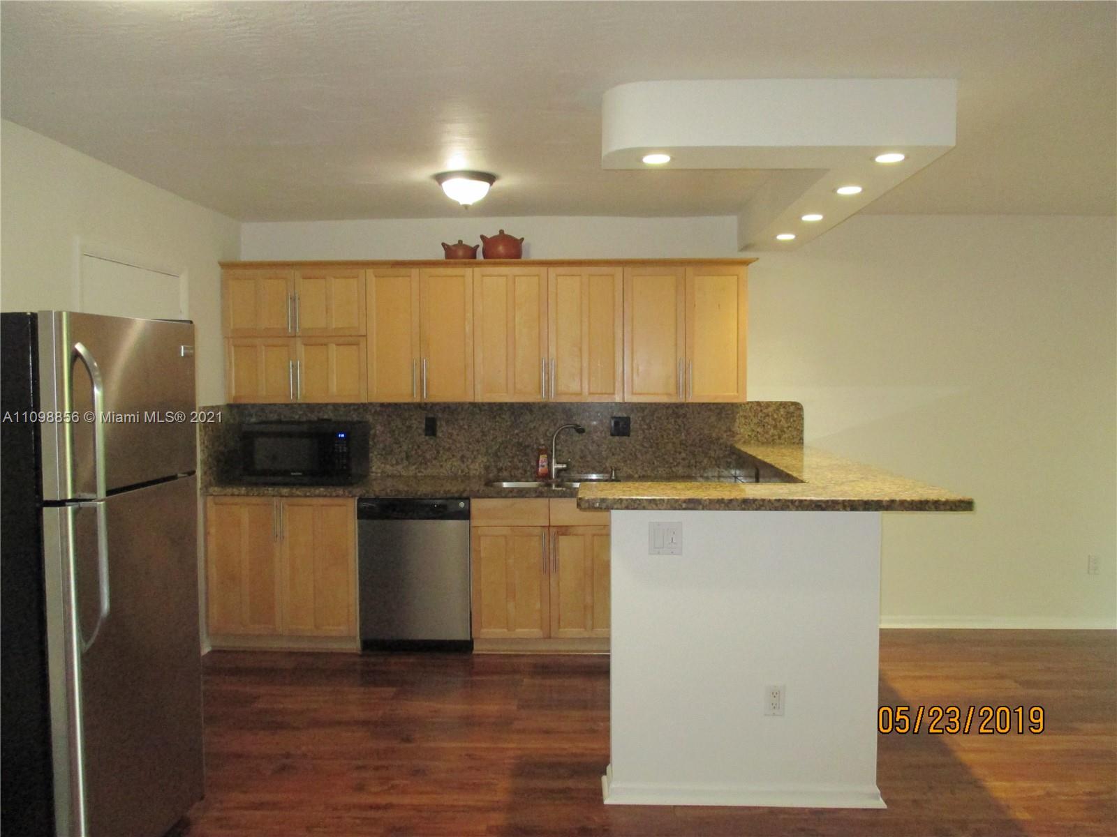 7483 Southwest 82nd Street, Unit A207 Miami, FL 33143 - Photo 5 of 27 a kitchen with a refrigerator and a sink